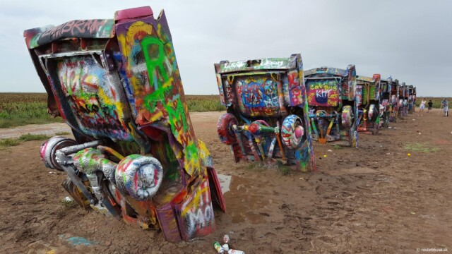 Rad farebných Cadillacov v piesku | Zdroj: route66usa.sk Farebné autá značky Cadillac zakopané v piesku na Cadillac Ranch v Amarillo, Texas